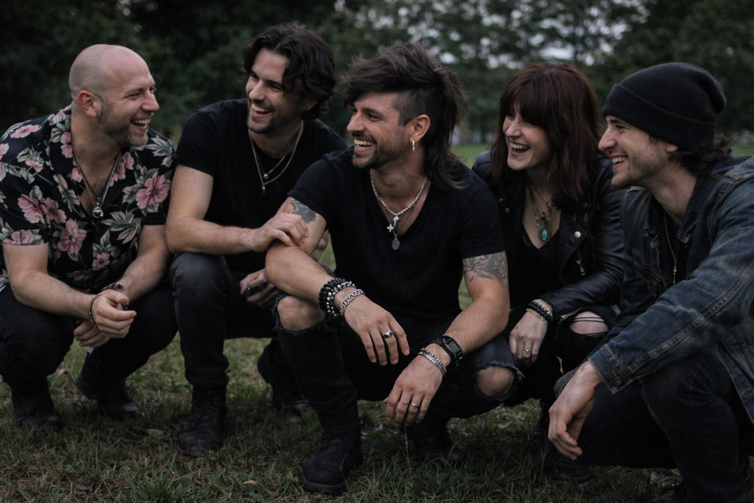 Foto informal de la banda riendo en el césped